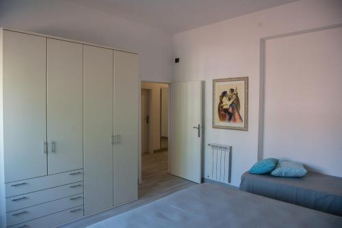 マリーナ・ディ・グロッセートにあるWonderful house in Marina di Grossetoの白いキャビネットとベッド付きのベッドルーム1室