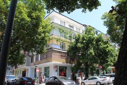 a building on a street with cars parked in front of it at OldBatumi Apartment in Batumi