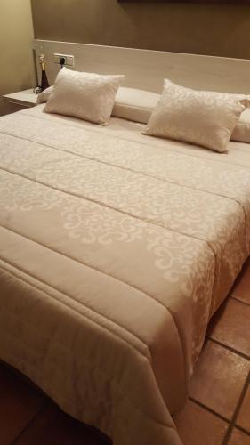 a large white bed with two pillows on it at Aparta-Hotel Puertolas in Escuer