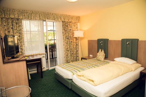 1 dormitorio con 1 cama, TV y ventana en Zum Dorfschmied en Klein Sankt Paul