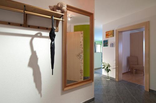 ein schwarzer Regenschirm hängt an einer Wand neben einem Spiegel in der Unterkunft Appartementhaus Charisma in Fieberbrunn