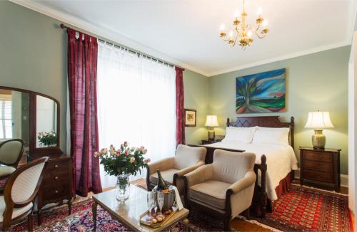 Un dormitorio con una cama, una silla y una mesa. en Historic Lyons House, en Niagara on the Lake