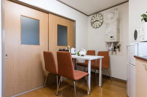 a kitchen with a table and chairs and a clock at Ogi-Ohashi Apartment in Tokyo