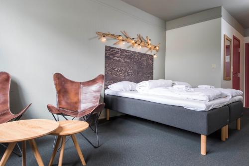 1 dormitorio con 2 camas, mesa y sillas en Trysil Hotel, en Trysil