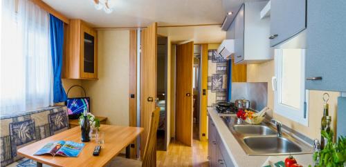 a kitchen with a sink and a wooden table at Camping Village Du Parc in Lazise
