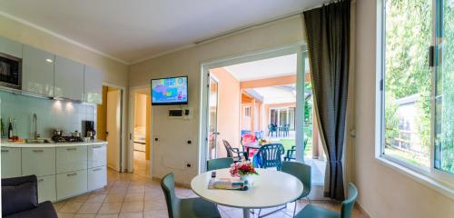 a kitchen and dining room with a table and chairs at Camping Village Du Parc in Lazise
