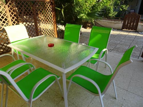 a table with green chairs and a red ball on it at Maria Petros Beach Houses in Perivolia