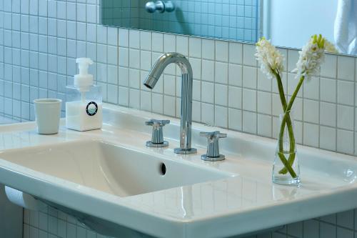 un lavabo con un jarrón con flores. en Hotel Reimar, en Sant Antoni de Calonge