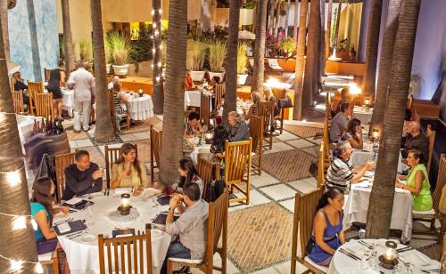 a group of people sitting at tables in a restaurant at Casa Natalia Boutique Hotel Adults Only in San José del Cabo