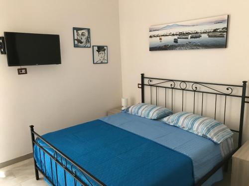 ナポリにあるCasa Fedoraのベッドルーム1室(ブルーシーツのベッド1台、薄型テレビ付)