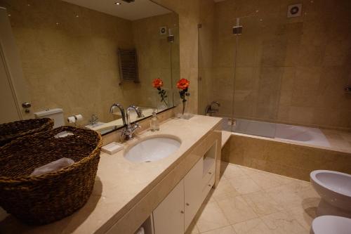 a bathroom with a sink and a toilet and a tub at White Guest House in Peniche