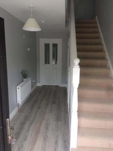 an empty hallway with stairs and a door at Grangegeeth Inn in Slane