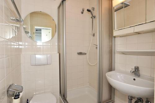 a bathroom with a shower and a toilet and a sink at Appartment-19-Sylter-Robbe in Wenningstedt
