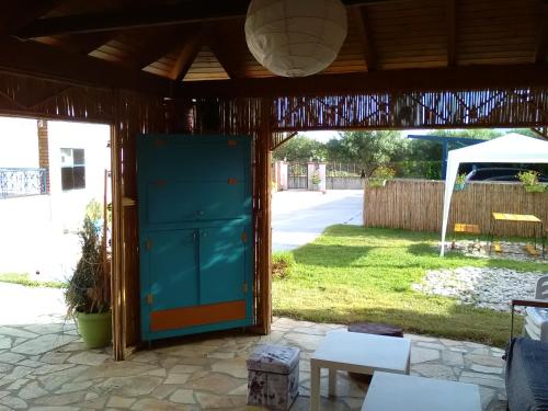a patio with a blue door in a yard at Armonia Studios in Agios Georgios
