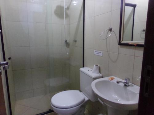 a bathroom with a shower and a toilet and a sink at Pousada do Cardoso in Angra dos Reis