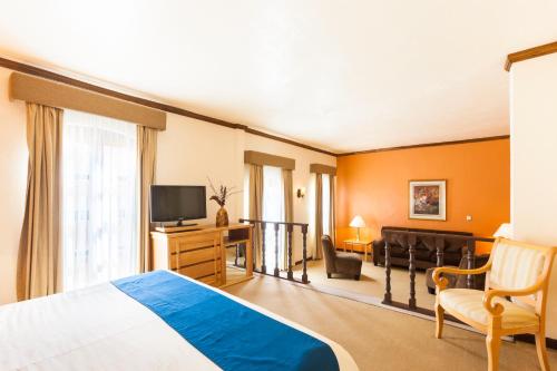 a hotel room with a bed and a television at Hotel Meson de Jobito in Zacatecas