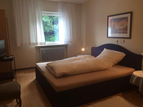 Dormitorio pequeño con cama y ventana en ICC Pfälzer Hof - Hotel & Seminarhaus en Schönau