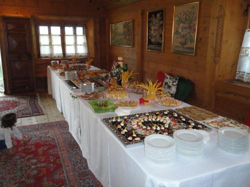 a row of buffet tables with plates and food at Hotel Edelhof in Tarvisio