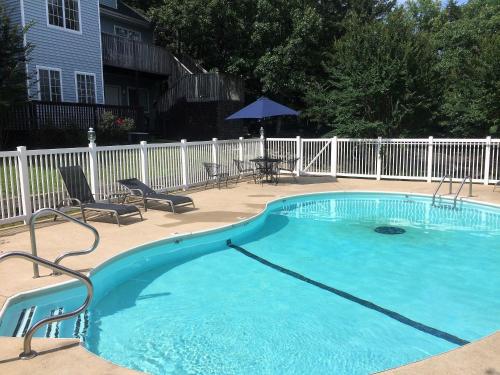 a swimming pool in a yard with chairs and an umbrella at Bradford House Bed and Breakfast in Branson