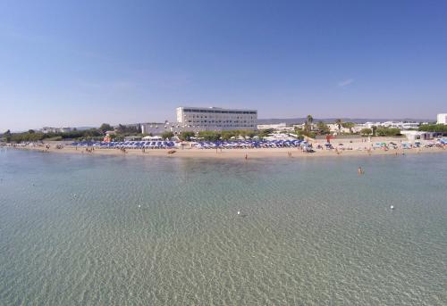 a beach with a bunch of people in the water at Hotel Del Levante in Torre Canne