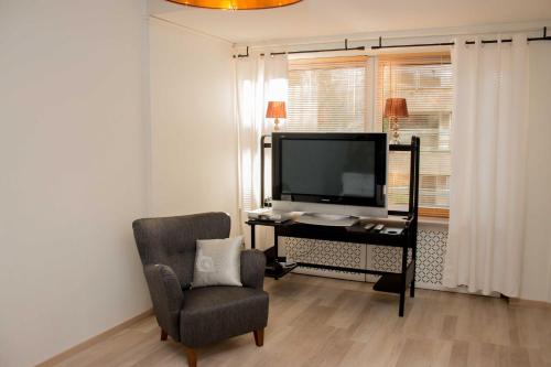 un salon avec une télévision et une chaise dans l'établissement Lahti Alex House, à Lahti