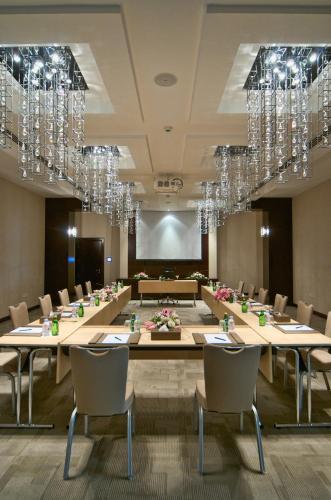 a large conference room with tables and chairs and chandeliers at City Seasons Hotel & Suites Muscat in Muscat