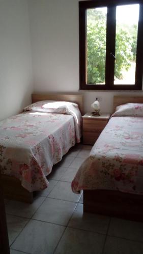 a bedroom with two beds and a window at Bithia Apartment in Chia