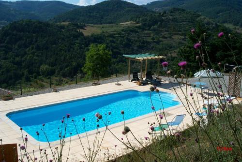 une piscine au milieu d'une montagne dans l'établissement Chambres d'Hôtes Le Crouzat, à Empurany