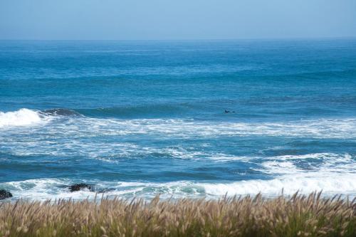 a person riding a wave in the ocean at Hotel Puerto Viejo Llico in Llico
