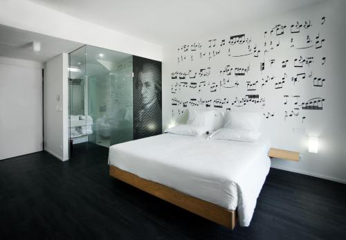 a hotel room with a bed, desk, and painting on the wall at Design Wine & SPA Hotel in Caminha