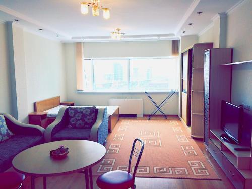 een woonkamer met een bank en een tafel bij Amasing apartment on Dostyk 5 str in Astana