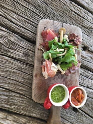 a wooden cutting board with a salad and dipping sauce at Blyde River Wilderness Lodge in Hoedspruit