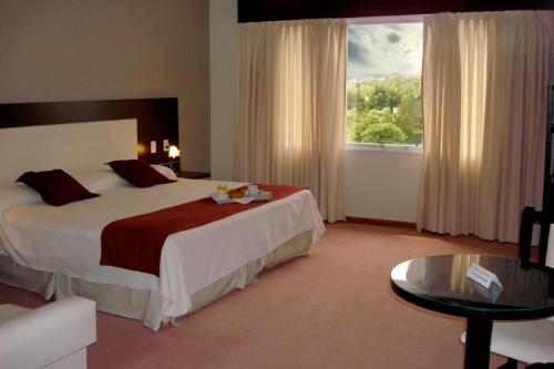 a hotel room with a large bed and a window at Hotel Cuatro Plazas in Casilda