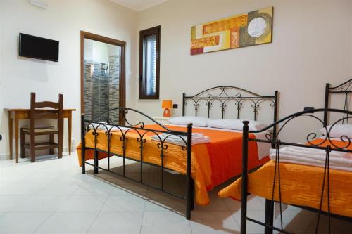 a bedroom with two beds with orange sheets at I Due Pini in Sogliano Cavour