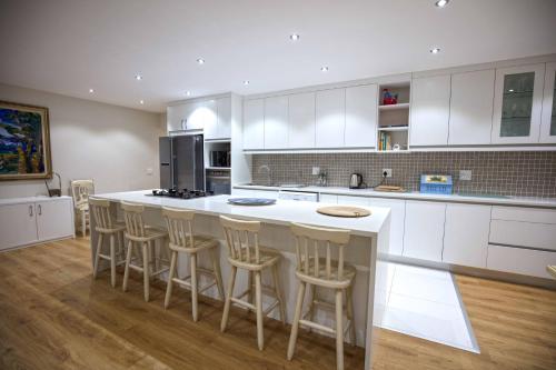 a kitchen with a large island with bar stools at No1 Sangaree in Plettenberg Bay
