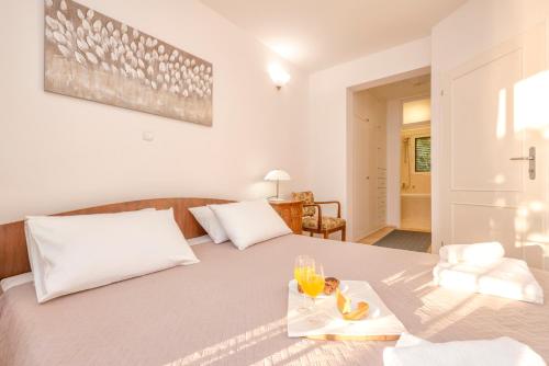 a bedroom with a bed with a tray of food on it at Pine Beach Villa in Hvar