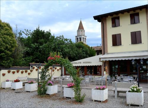 a building with tables and flowers in front of a building at Alla Basilica in Aquiléia