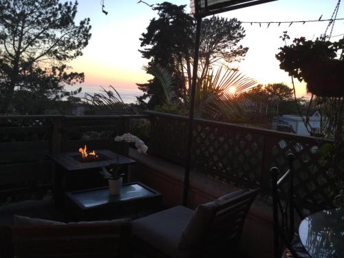 a sunset on a balcony with a table and chairs at Les Artistes Inn in San Diego