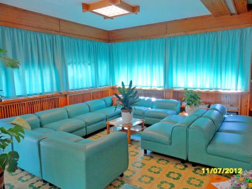 a living room with blue couches and blue curtains at Hotel Prati in Castrocaro Terme