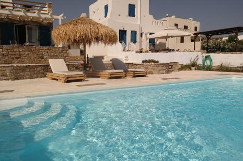 a swimming pool with two lounge chairs and a house at Villa Mozaik in Plaka