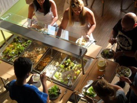 a group of people standing around a buffet line with food at Hellmut-Waßmer-Jugendherberge Lörrach in Lörrach