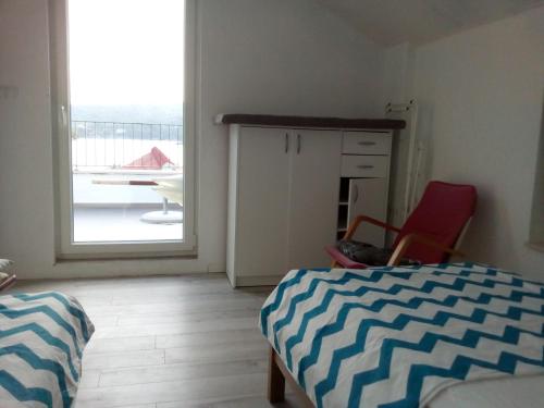 a bedroom with a bed and a door to a balcony at Apartment More Sumartin in Sumartin