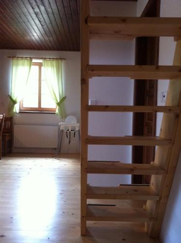 a ladder to the loft bed in a room with a window at Penzion Terezka in Králíky