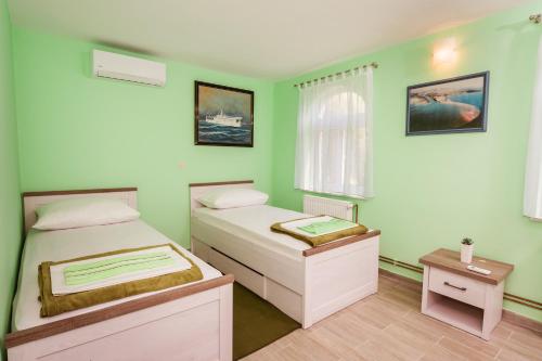 two beds in a room with green walls at Villa Usce in Komin