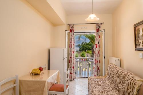 a living room with a table and a refrigerator at Villaggio Verde in Laganas
