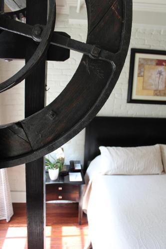 a bedroom with a bed and a wooden spiral staircase at La Galerie French Quarter Hotel in New Orleans