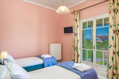 a bedroom with two beds and a window at Villaggio Verde in Laganas