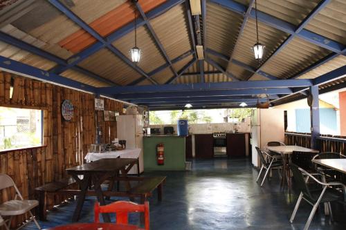 a restaurant with tables and chairs and a kitchen at Hostal Amador Familiar in Panama City