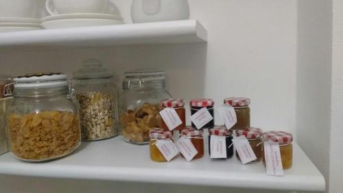 a refrigerator shelf with jars of food and nuts at La vie est belle in Finale Ligure