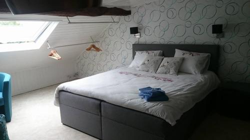 a bedroom with a bed with a blue bag on it at B&B Chambre d'hôtes de la Vecquée in Stoumont